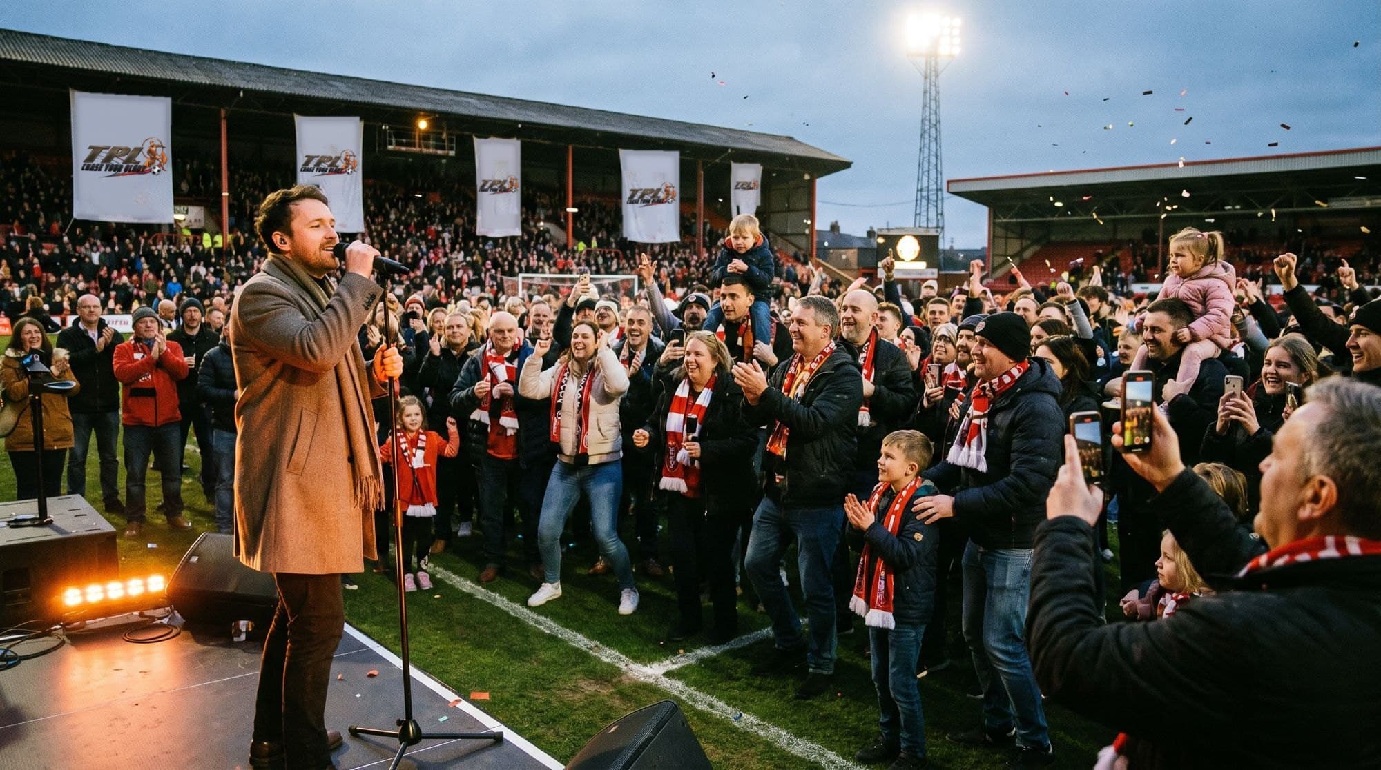 A half-time music performance on a pitch-side stage in front of cheering fans